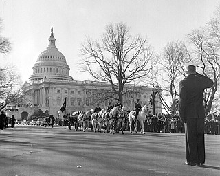 A horse-drawn caisson carrying the flag-draped casket of the late President John F. Kennedy moves out of the Capitol plaza en route to St. Matthew's Cathedral for funeral services, Nov. 25, 1963.  