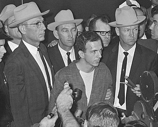 Lee Harvey Oswald is shown early Nov. 23, 1963, as he stood before newsmen in a Dallas police station where he repeatedly denied that he had assassinated President Kennedy yesterday.  "I did not kill President Kennedy," he said. "I did not kill anyone. I don't know what this is all about." He was brought before the newsmen just after formal charges of murder were filed against him.   