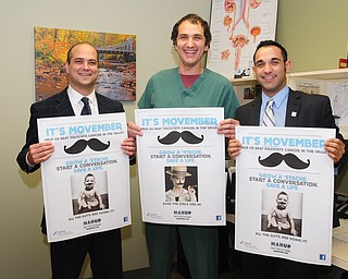 Dr. Dan Ricchiuti, left,  surgical assistant Andrew Labedz, and HMHP Foundation special events/prospect manager Jonathon Fauvie showed off Movember notices from Man Up Mahoning Valley at the Boardman office of NEO Urology.