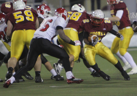Cardinal Mooney's C.J. Amill (2) cuts through a hole in the Steubenville defense before being met by Steubenville's Jeremy Blue (25) during the second quarter of Friday nights Division four Semi-Finals matchup at Fawcett Stadium in Canton.  Dustin Livesay  |  The Vindicator  11/29/13  Fawcett Stadium, Canton.
