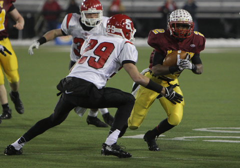 Cardinal Mooney's C.J. Amill (2) attempts to juke around Steubenville's Niko Petrides (29) during the second half of Friday nights Division four Semi-Finals matchup at Fawcett Stadium in Canton. Amill rushed 17 times for 82 yards and a touchdown in Mooney's 37-7 victory over the Big Red.  Dustin Livesay  |  The Vindicator  11/29/30  Fawcett Stadium, Canton Ohio.