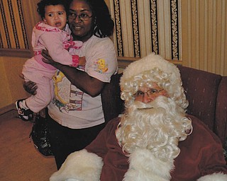 One-year-old Miya Moore, who is held by her godmother, Othella May, refuses to sit on Santa's lap.