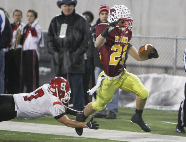 Cardinal Mooney’s Mark Handel (22) eludes a tackle by Steubenville’s Bryan Pierro (7) during the second quarter of their Division IV semifinal game at Fawcett Stadium in Canton.