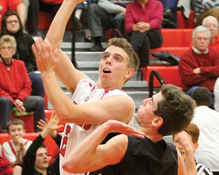 Girard’s Jim Standohar shoots against Howland’s Evan Steele during their game Tuesday in Girard. The Indians defeated the Tigers, 65-59.