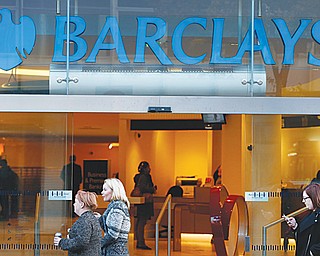 People walk past a branch of Barclays Bank in London on Wednesday. The European Commission has fined a group of major global banks, including Barclays, a total of $2.3 billion for colluding to profit from the interest-rates market. The banks are accused of manipulating for years European and Japanese benchmark interest rates that affect hundreds of billions of dollars in contracts globally, from mortgages to credit card
bills.