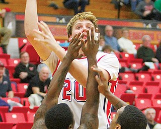 Youngstown State’s Bobby Hain shoots over Robert Morris defenders Anthony Myers-Pate (5) and Mike McFadden (1) during their game Wednesday at Beeghly Center. The Penguins downed the Colonials, 84-76.