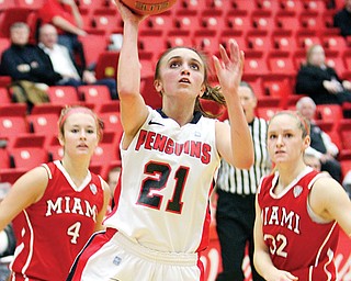 Youngstown State’s Liz Hornberger shoots past Miami of Ohio defenders Maddie McCallie (4) and Hannah Robertson (32) during their game Wednesday at Beeghly Center. The Penguins fell to the RedHawks, 70-67, in the final minutes.