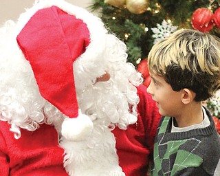Zachary Krk, 3, of Struthers sits on Santa’s lap while reviewing his Christmas wish list. Santa visited Mauthe Park in Struthers on Thursday as part of the city’s annual Christmas in the Park event.