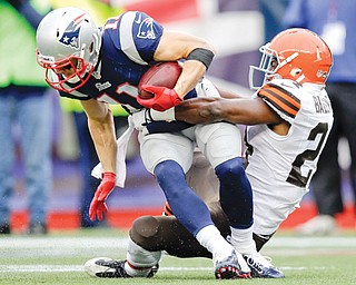 Cleveland Browns cornerback Johnson Bademosi, right, tackles New England Patriots wide receiver Julian Edelman after a catch in the second quarter of Sunday’s game in Foxborough, Mass.