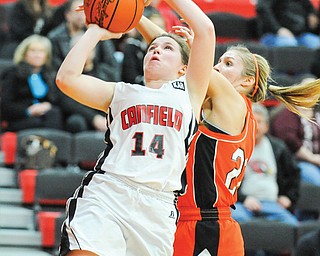 Canfield’s Lynnae Whitehead (14) shoots after dribbling around Howland’s Gabby Cvengros during Monday’s game in Canfield. The Cardinals won the All-American Conference American Division game, 59-58.
