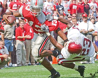 Ohio State tailback Maurice Clarett (13) fends off a tackle attempt by Indiana free safety A.C. Carter (23) during a game at Ohio Stadium. Clarett, a former Warren Harding High School standout, helped the Buckeyes win the national championship that season. It ended up being his only season at Ohio State.