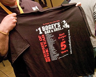 Chef McKee holds a T-shirt after receiving the Burger of the Year Award.