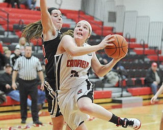 Canfield’s Rachel Tinkey (21) drives past Struthers’ Brittaney Zupko on her way to the basket Thursday night. The
visiting Wildcats beat the Cardinals, 60-57, in an All-American Conference, American Division game.
