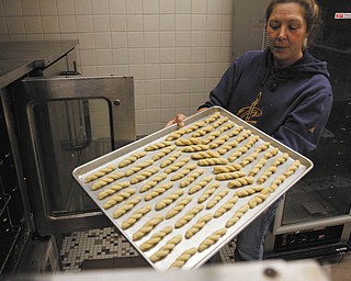 ROBERT K. YOSAY | THE VINDICATOR:
Dorothy Kippner places the koulourakia in an oven at St. John’s Greek Orthodox Church on Glenwood Avenue., when the church women met recently to bake for their annual cookie fundraiser.
