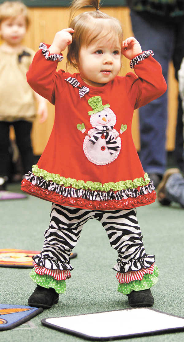 Adalyn DeLuca, 14 months, sings and moves to the music to touch her head, shoulders, knee and toes during
a Rhythm and Rhyme session. Dan DeLuca, Adalyn’s father, brought her to the session.