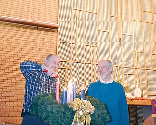 The Rev. Glenn Hamilton, left, pastor of Grace United Methodist Church in Warren, lights the Christ candle in the Advent wreath as he will do during a Longest Night Service planned at 7 p.m. Wednesday at his church. Watching is the Rev. Dr. Jim Ellison, pastor of Tod Avenue United Methodist Church in Warren, who will be among Methodist clergy joining together for the service of remembering and healing.