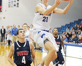 Poland’s Kyle Dixon (21) goes in for a layup Tuesday night during the second quarter against visiting Austintown Fitch. The Bulldogs beat the Falcons, 65-48. Fitch’s Gabriel Chepke (4) is at left and Quincy Higgins (22) at right.