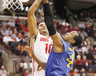 Ohio State’s LaQuinton Ross tries to block a shot by Delaware’s Jarvis Threatt during the first half of their game Wednesday in Columbus. The No. 3 Buckeyes bounced the Blue Hens, 76-64, behind Ross, who led OSU with 19 points.