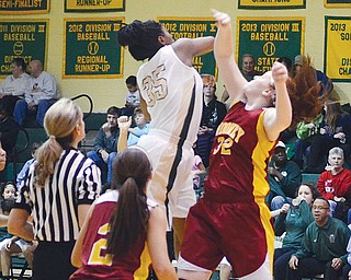 Ursuline’s Tanaya Beacham swats the ball away from Cardina Mooney’s Maggie Monahan at the start of Wednesday’s game at Ursuline High School. Beacham scored 18 points for the Irish, who downed the
Cardinals, 47-39.