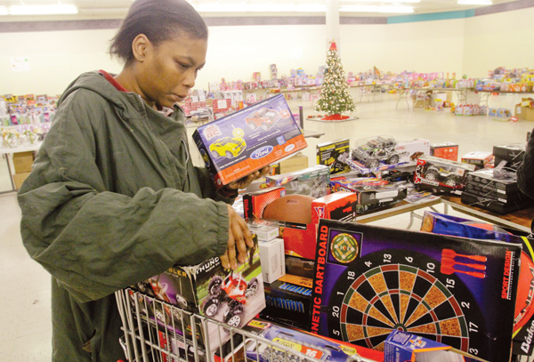 Nikesha Curry of Youngstown looks for Christmas gifts for her children in the toy section at the Salvation Army’s
distribution center in the Austintown Plaza on Mahoning Avenue. Families who have not registered for a shopping
day at the center can still sign up from 1 to 3 p.m. Friday .