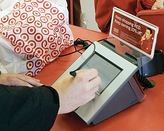 A customer signs his credit-card receipt at a Target store in Tallahassee, Fla. The U.S. is the juiciest target for hackers hunting credit-card information, and experts say incidents such as the recent data theft at Target’s stores will get worse before they get better.