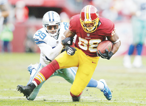 Washington Redskins receiver Pierre Garcon, a former standout at Mount Union University, is tackled by Dallas Cowboys cornerback Brandon Carr during the second half of their game Sunday.
