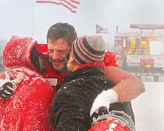 Youngstown State football player Fred Herdman (57) embraces his brother Justin Herdman, left, and father Fred Herdman Sr. after YSU’s 42-13 loss to South Dakota on Nov. 23 at Stambaugh Stadium. It was the Penguins’ final game of the season.