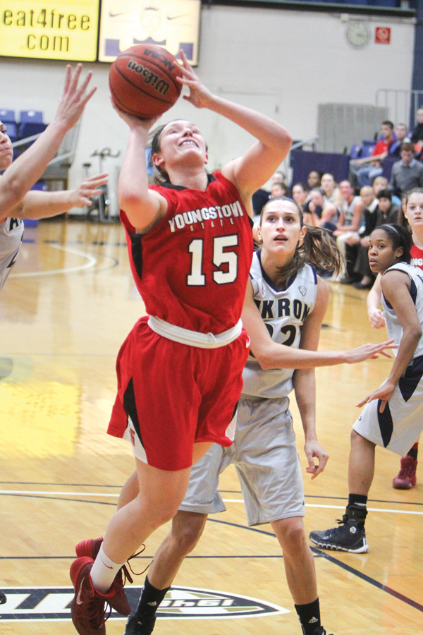 YSU’s Heidi Schlegel goes for a layup after being fouled by Akron’s Rachel Tecca during Sunday’s game in Akron. Schlegel tied her career high in single game points with 27, but the Penguins fell 91-75 to the Zips.