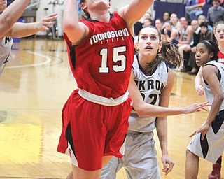 YSU’s Heidi Schlegel goes for a layup after being fouled by Akron’s Rachel Tecca during Sunday’s game in Akron. Schlegel tied her career high in single game points with 27, but the Penguins fell 91-75 to the Zips.