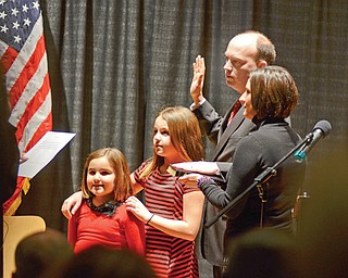 Flanked by his daughters, Cara and Casey, and wife, Virginia, John A. McNally takes the oath of office as Youngstown’s 50th mayor Monday at DeYor Performing Arts Center downtown.