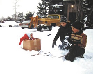 From Kathy Miller: "In either December 1984 or January 1985, our third son, Tyler, was 7 or 8 months old and wanted to be with the older kids outside. They created the box on the sled and pulled him around the yard. My mother-in-law had made the little red winter jacket for Tyler. Friend and neighbor up the street on Creston in Boardman (we still live there) is Stephen Bupp and Tyler's older brother, Nathan, in beige/tan jacket dreamed up the box on a sled idea. I sent this to my family in an email as a quiz on Christmas asking who were in the picture and what year it was taken. It was hard to believe that no one got it right. The years have sure flown by."