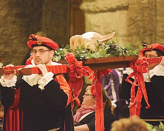 Jason Lisko, left, carries the boar’s head with his brother, Josh, at Sunday’s 53rd annual Boar’s Head and Yule Log Festival at St. John’s Episcopal Church in downtown Youngstown.