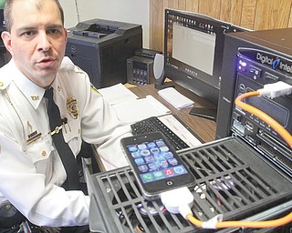 Youngstown police Capt. Jason Simon demonstrates the way a cellphone can be checked in the department’s
computer and cellular forensics room.
