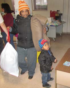 Kerrie Smith of Warren and her son leave the Salvation Army on Franklin Street with coats and other items they
can use to get through the winter. They were among scores of people who came Monday morning to the giveaway, prompted by the bitter-cold temperatures coming to the Mahoning Valley this week.