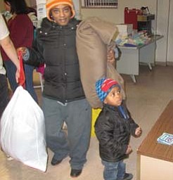 Kerrie Smith of Warren and her son leave the Salvation Army on Franklin Street with coats and other items they
can use to get through the winter. They were among scores of people who came Monday morning to the giveaway, prompted by the bitter-cold temperatures coming to the Mahoning Valley this week.