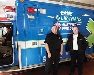 Austintown Fire Chief Andy Frost III, left, and Randy Pugh, vice president of Lane LifeTrans, stand by a new ambulance. LifeTrans has joined with the fire department to serve the Austintown community.