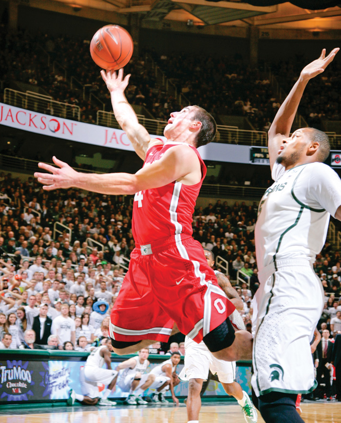 Ohio State’s Aaron Craft puts up a layup against Michigan State’s Adreian Payne during the first half of their NCAA basketball game Tuesday in East Lansing, Mich. The No. 5 Spartans edged the No. 3 Buckeyes, 72-68, in overtime.
