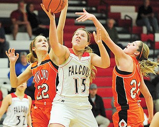 Howland ‘s Gabby Cvengros (22) and Sara Price (20) try to steal the ball off Fitch’s Cassie Custer as she goes to the basket during the first half of their game Thursday in Austintown. The Falcons downed the Tigers, 65-41.