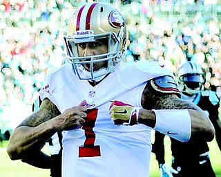 San Francisco 49ers quarterback Colin Kaepernick pantomines ripping open his shirt after scoring a touchdown against the Carolina Panthers during the third quarter of the NFC divisional playoff game Sunday at Bank of America Stadium in Charlotte, N.C. The 49ers won 23-10 to advance to the NFC championship against the Seattle Seahawks this Sunday in Seattle.