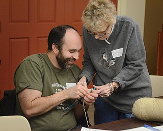 Dorothy Voitus teaches Joe Marino some of the fine points of knitting during a class recently at the Boardman branch of the Public Library of Youngstown and Mahoning County.