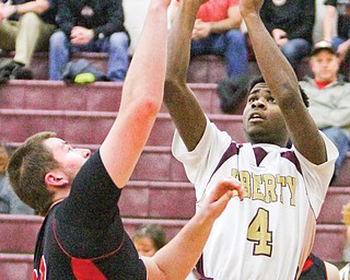 Liberty’s Asim Pleas (4) shoots over Salem’s Max Wolfgang during a game Tuesday in Liberty. Pleas scored 30
points, leading the Leopards over the Quakers, 73-67.
