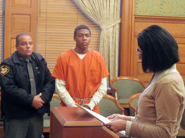 Taylor Ervin-Williams, center, listens as MaryJo Hoso, a victim-witness advocate in Trumbull County, reads a statement to Judge Ronald Rice. Standing next to Ervin-Williams is Deputy Dominic Massary. Judge Rice sentenced Ervin-Williams to 41 years in prison on kidnapping and robbery charges Wednesday.