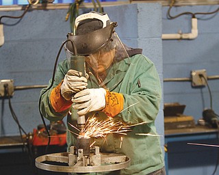 Ashley Basista of Struthers grinds a bevel into a 2-inch pipe. She is involved in an apprentice program to train
Mahoning Valley residents for skilled-labor jobs in the oil and gas industry.