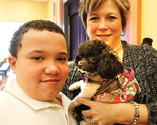 Rhyan Pegues, a fifth-grader at Youngstown’s McGuffey Elementary School, and Paula Cipriano, a special-education teacher at the school who works with Legacy Dog Rescue, pose with Nessa, a dog Legacy found a new home for after Dr. John Owen, a Howland veterinarian, repaired her broken leg.