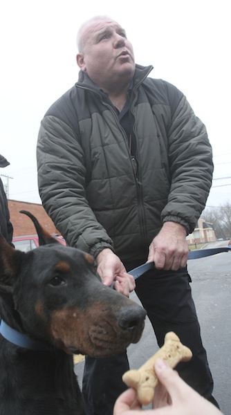 Chris Flak, Mahoning County humane agent, with 1 of the 105 dogs confiscated during the raid at Terri Wylie's Smith Township property.