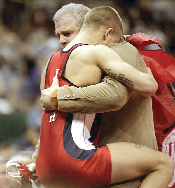 Tony Jameson, of Austintown Fitch, hugs his coach, Brett Powell, after winning the Division I 145-pound championship during the 71st annual state wrestling tournament at OSU’s Schottenstein Center in Columbus. Powell will go for his 250th dual meet victory on Wednesday.