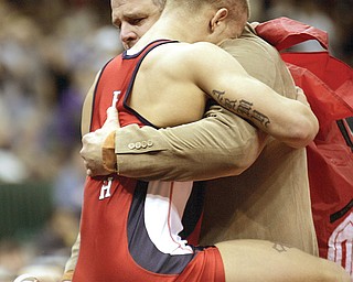Tony Jameson, of Austintown Fitch, hugs his coach, Brett Powell, after winning the Division I 145-pound championship during the 71st annual state wrestling tournament at OSU’s Schottenstein Center in Columbus. Powell will go for his 250th dual meet victory on Wednesday.