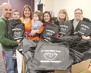 Posing with school-supply bags to be distributed to students in Campbell City Schools are members of The Michael “Mickey” Soroka Charitable Foundation, from left, Eric Gonzalez, holding son, Gavin, 4; Carmel Gonzalez, Eric’s wife, holding their daughter, Elena, 1; Jennifer Kavouras, Rena Regula and Andrea McGoogan. Foundation members gathered Wednesday to fill bags to be distributed district wide Friday, weather permitting. The foundation was founded to carry on the legacy of Soroka, a Campbell High School teacher who went out of his way to help students whether they were enrolled in his classes or not. Soroka died in 2011 at age 49.