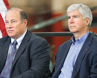 Detroit Mayor Mike Duggan, left, and Gov. Rick Snyder listen to a speaker at the IDEAL Group on Thursday in Detroit. Snyder announced a plan to ask the Obama administration to set aside thousands of work visas to entice talented immigrants to live and work in bankrupt Detroit. The Republican governor said he is seeking 50,000 work visas solely for the city over five years.