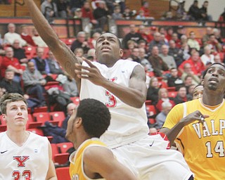 Youngstown State’s Kendrick Perry puts up a layup over Valparaiso defender Lexus Williams during their game Thursday at YSU’s Beeghly Center. Perry was one of four Penguins in double digits, but YSU fell, 74-71, to the Crusaders.